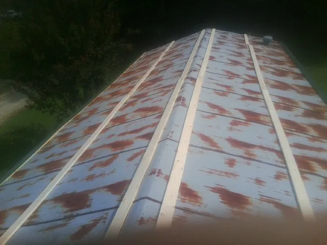 Rusted metal roof panels with new wood purlins before replacement — Storm Damage Roof Repair in Frederica by Roofing Brothers