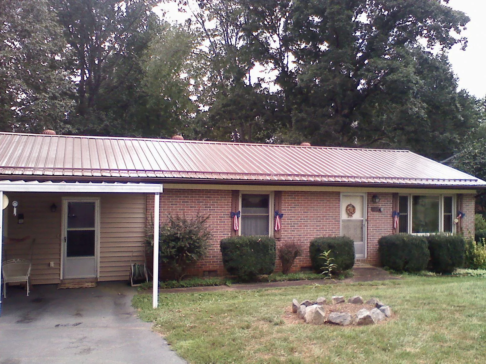 Bronze metal roof and carport on a brick ranch home — Roof Repair work by our crew in Frederica